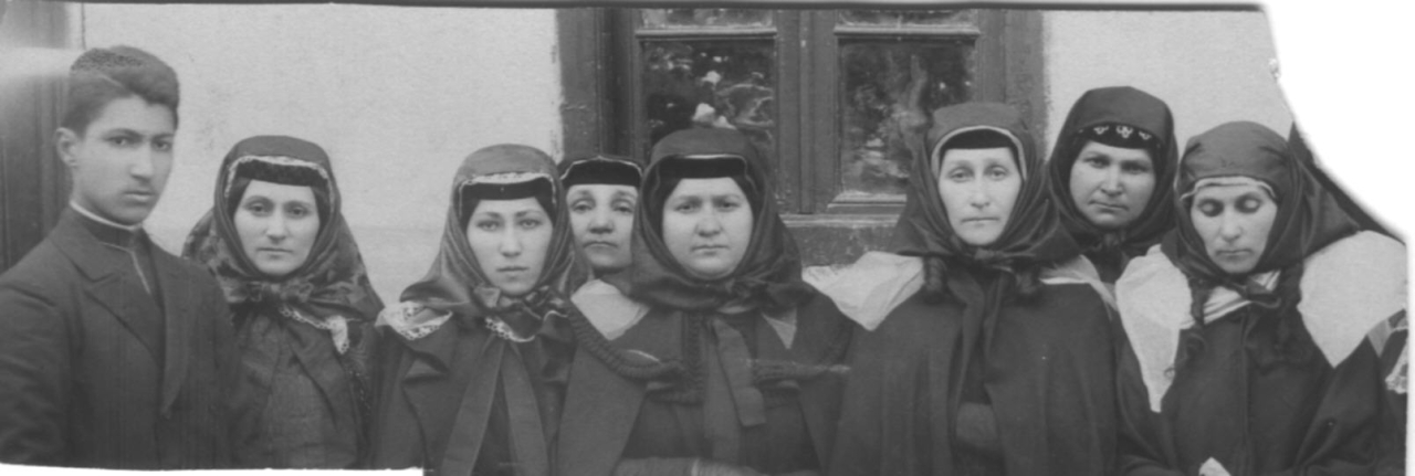 Թիֆլիսի քաղաքային տարազով մի խումբ կանայք և մի երիտասարդ: Ձախից երկրորդը Քոչարի մայրը՝ Ֆեոկլա Մարտիրոսյանը: Թիֆլիս, 19-րդ դարի վերջ 