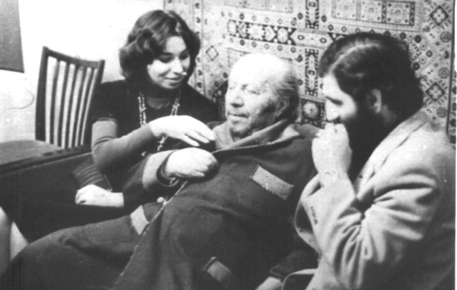 Ե. Քոչարը /կենտրոնում/ մի երիտասարդ կնոջ և մի տղամարդու հետ բազմոցին նստած,  [1970-ականներ]